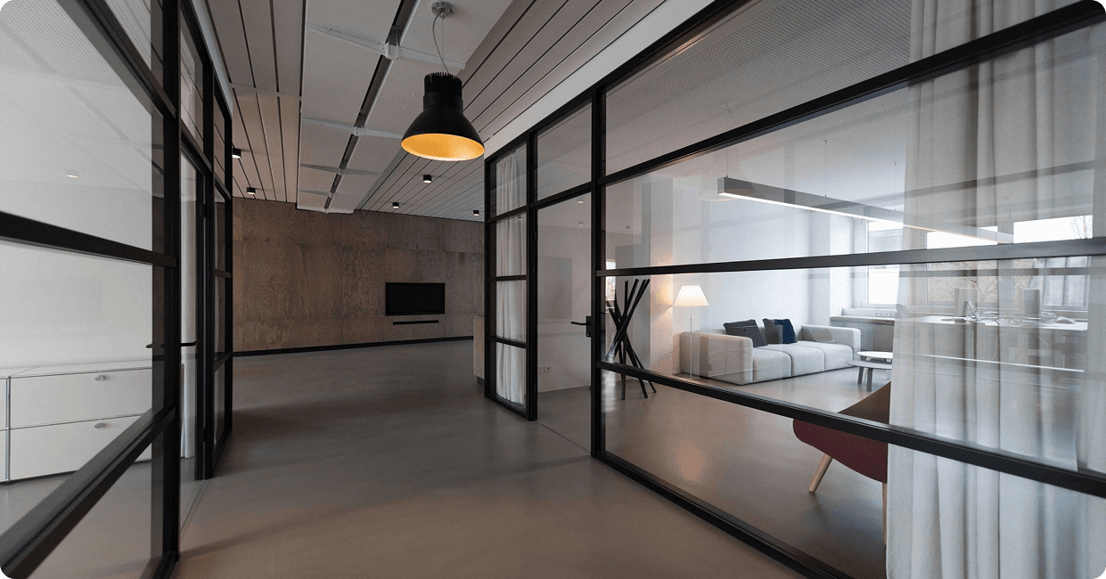 A modern CoWork Kerala coworking space with glass-walled offices and shared desks